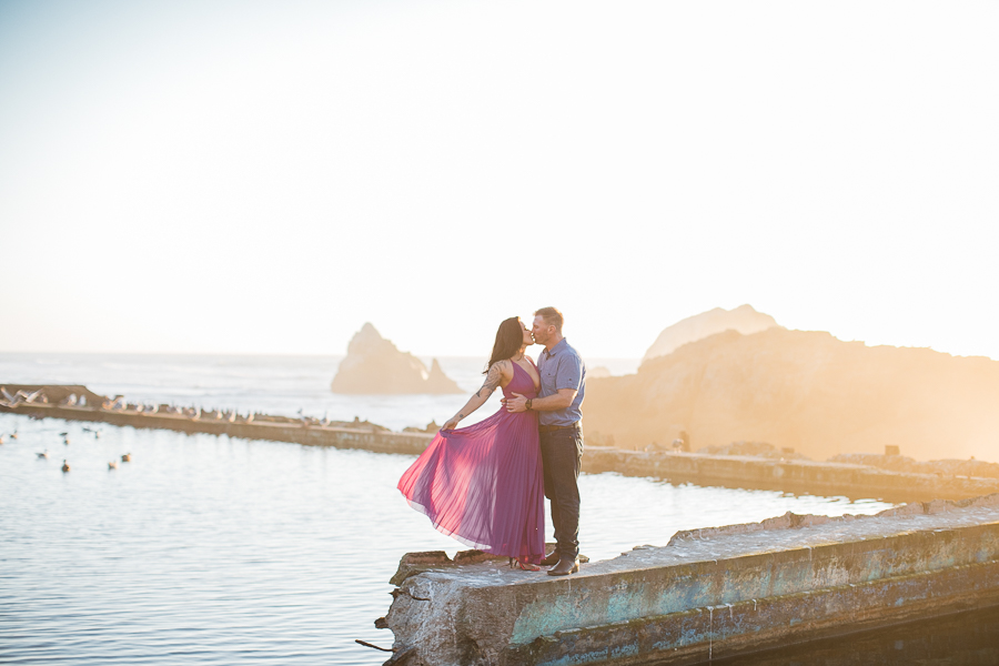 a couple kisses during engagement photos at Sutro Baths