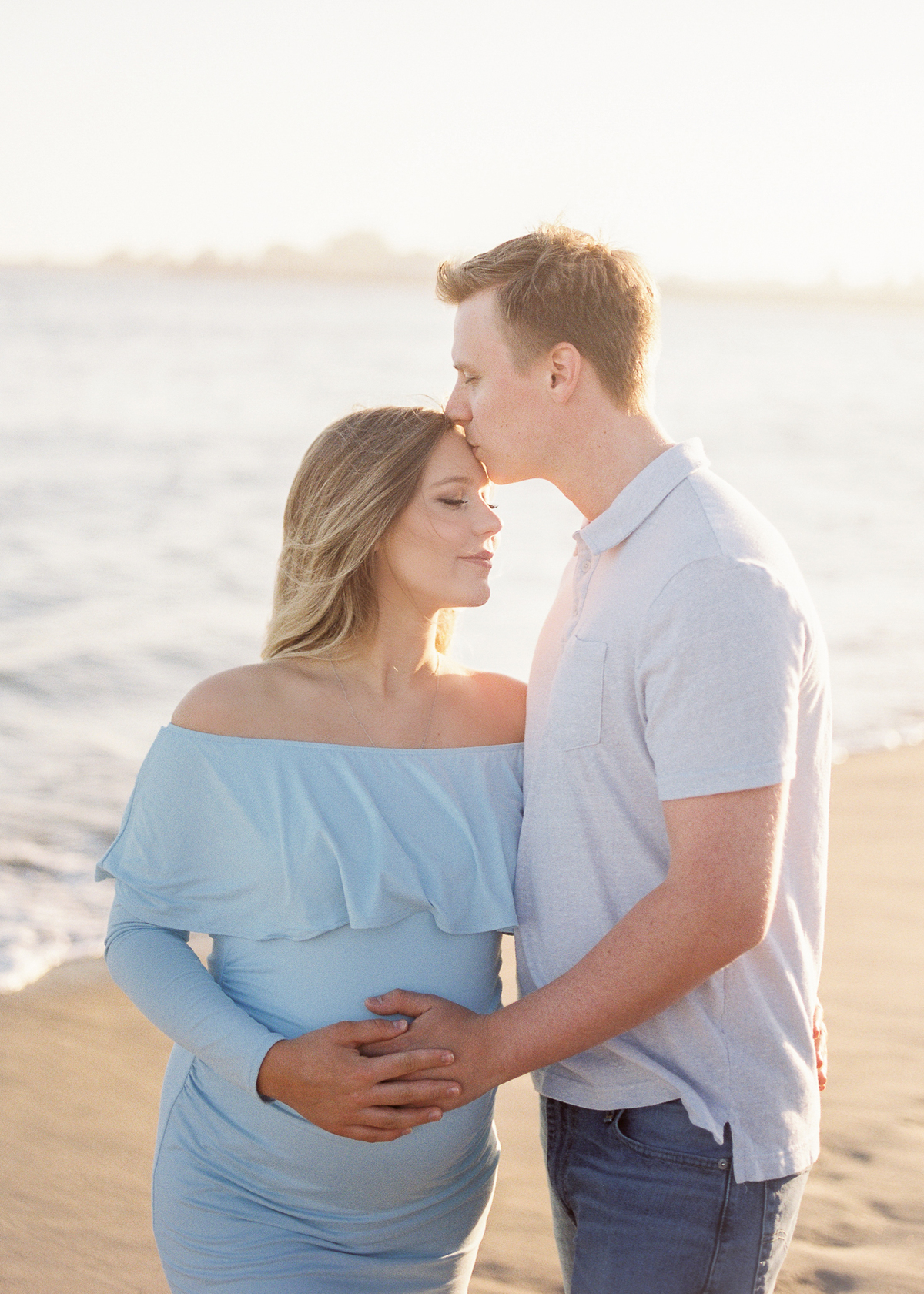 husband and wife have maternity photos at the beach for tips for beach photos